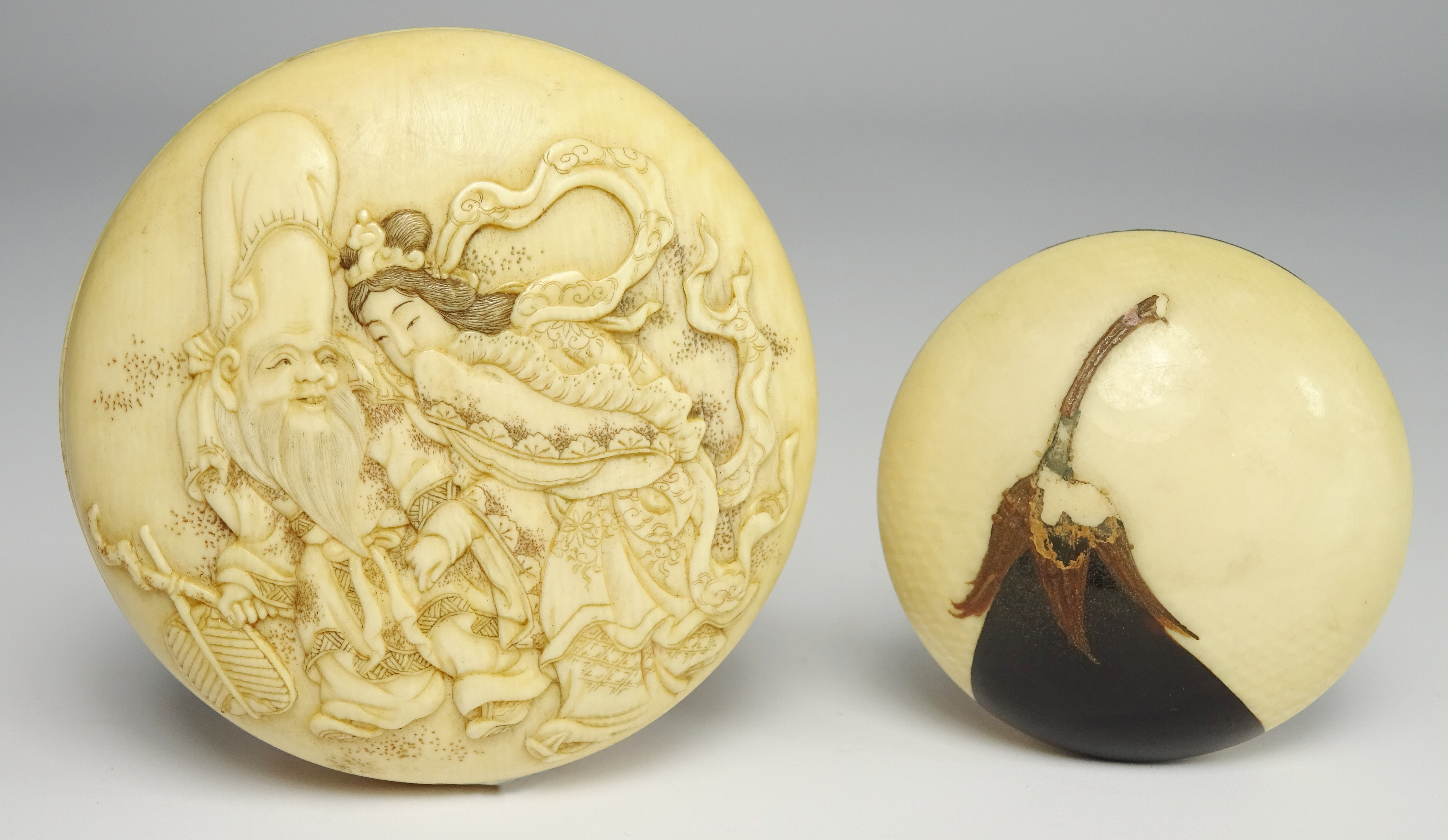 Japanese ivory Kagamibuta Netsuke carved with figures and with further figures and signature to the