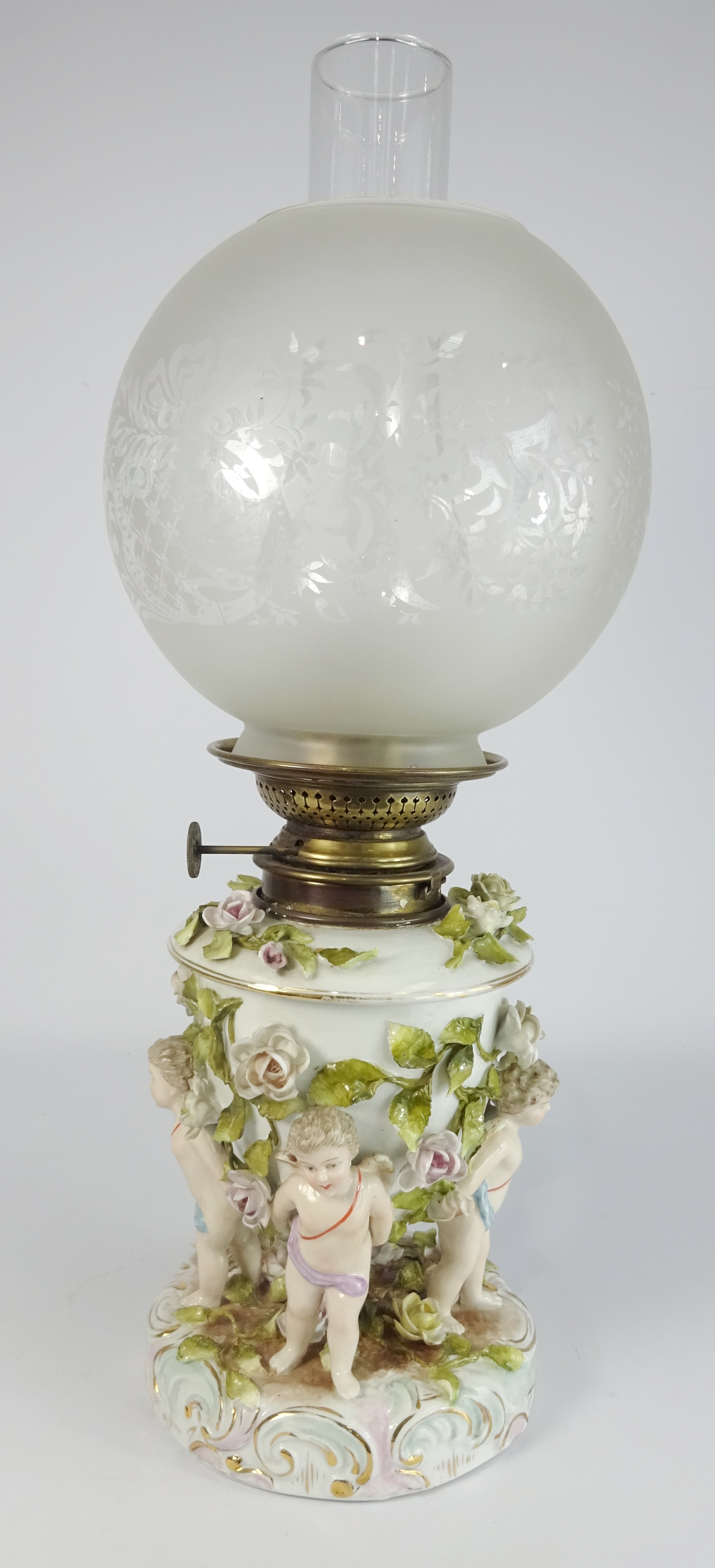 Thuringian Table oil Lamp, the base with encrusted flowers and on cherub supports, H51cm.