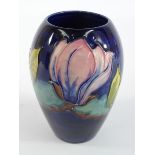Moorcroft oviform Vase decorated with magnolia on a dark blue ground. 12cms high.