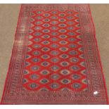 Afghan rug, red ground with repeating Gul motifs, geometric border and guards,