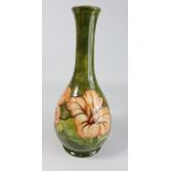 Moorcroft bottle shaped vase decorated with pink Hibiscus on a green ground,