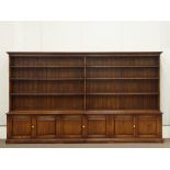 Large medium oak two sectional bookcase on cupboard, projecting dentil cornice above shelves,