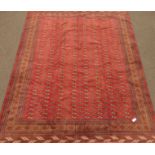 Turkoman red ground carpet, decorated with repeating Gul motifs,