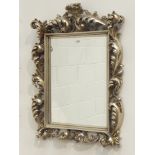 Ornate silvered Florentine style framed bevelled mirror, scrolled acanthus leaves with pediment,