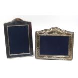 Silver freestanding photograph frame embossed scroll and foliage decoration and a plain silver