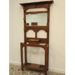 Arts & Crafts period oak hall stand, rectangular bevelled mirror back with coat hooks,