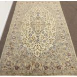 Persian Kashan ivory ground rug, interlacing blue floral design with repeating border,