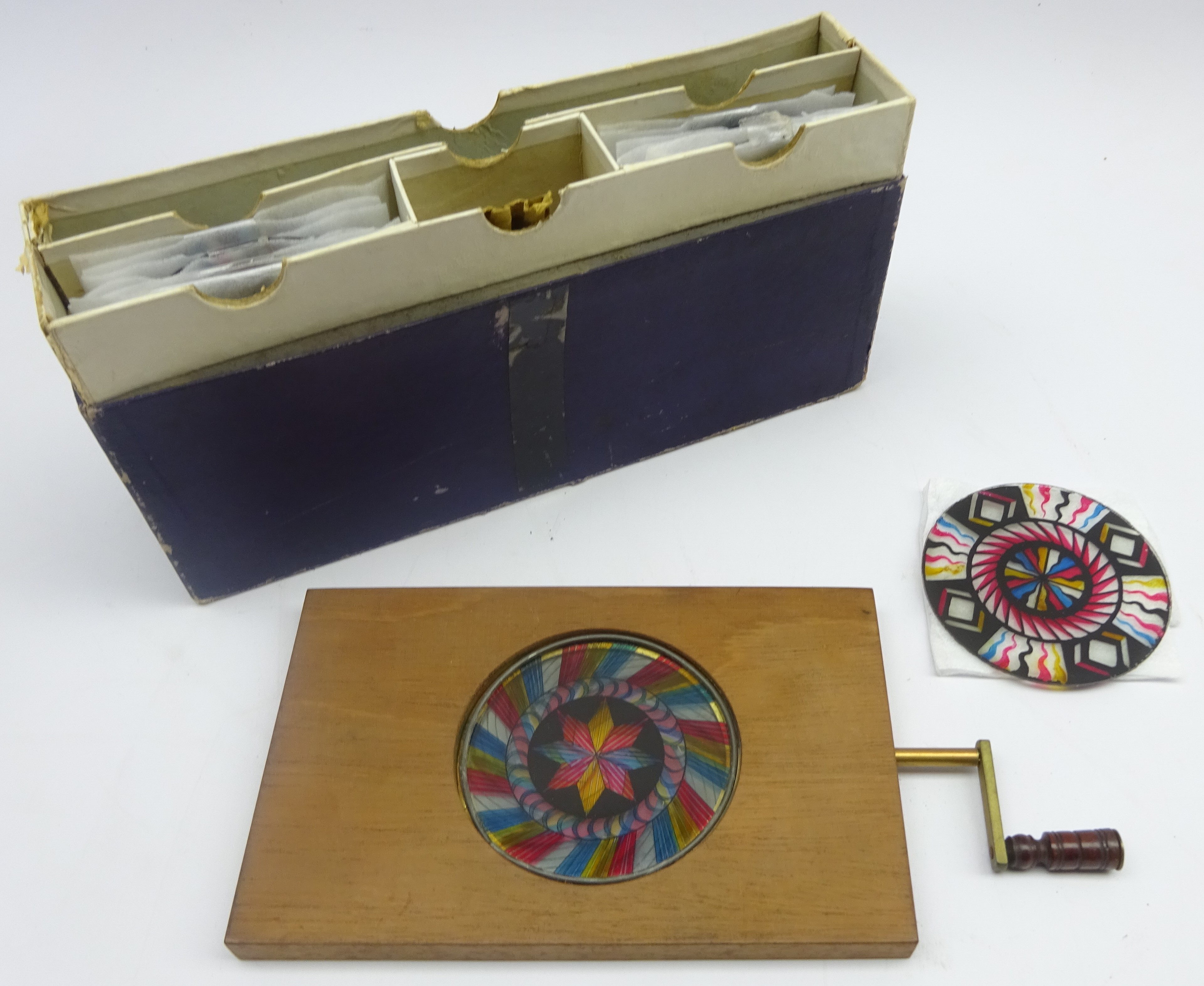 Hand held kaleidoscopic mechanical slide viewer with a collection of glass slides