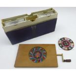 Hand held kaleidoscopic mechanical slide viewer with a collection of glass slides