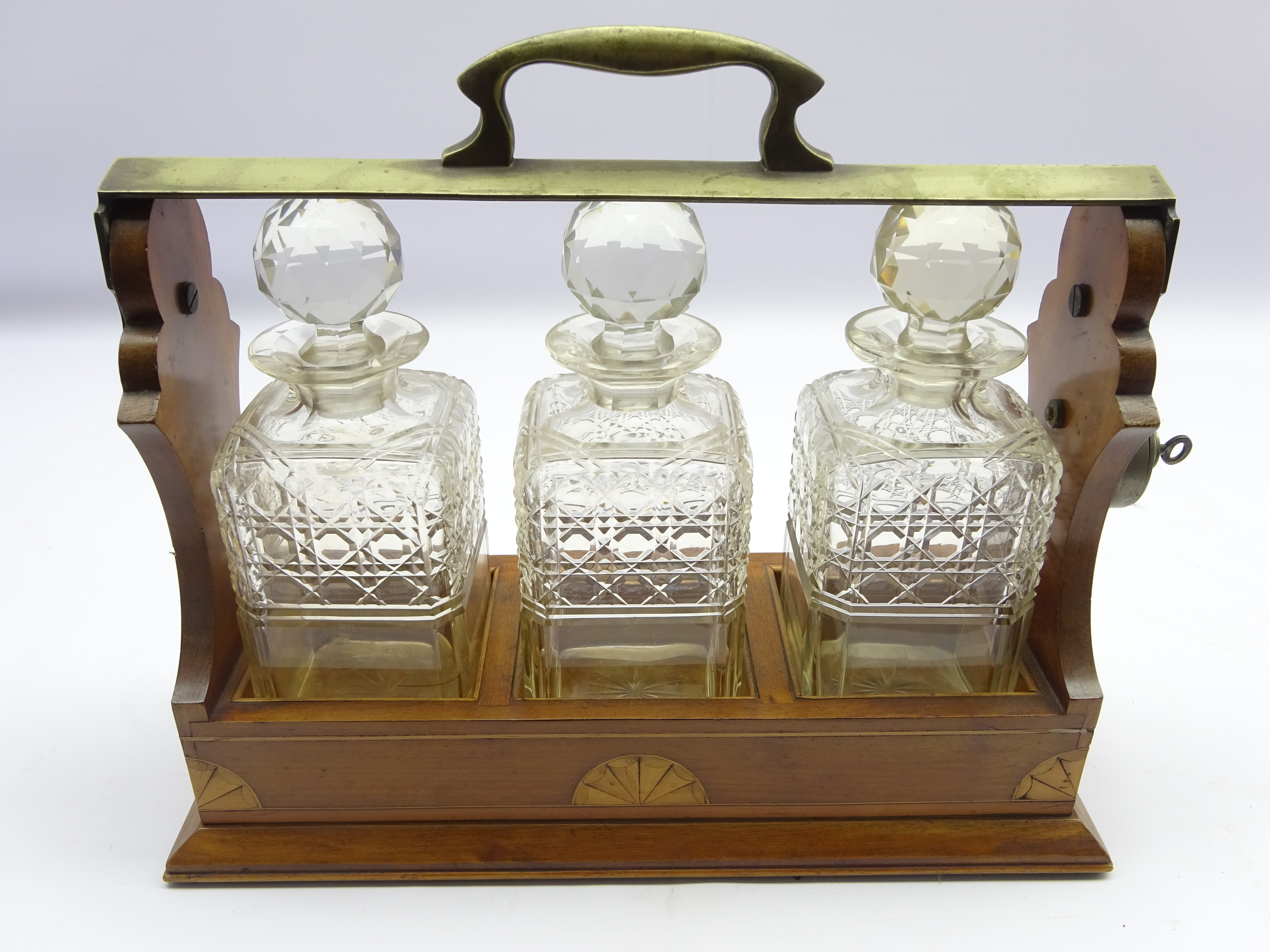 Edwardian three bottle tantalus in an inlaid mahogany and plated frame and fitted with three square