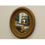 Late 19th century oval mirror, swept gilt framed,