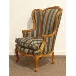 French style carved walnut wingback armchair upholstered in striped fabric with loose seat cushion