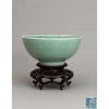 A large celadon-glazed ‘peony scroll' bowl,Qianlong six-character seal mark and of the period