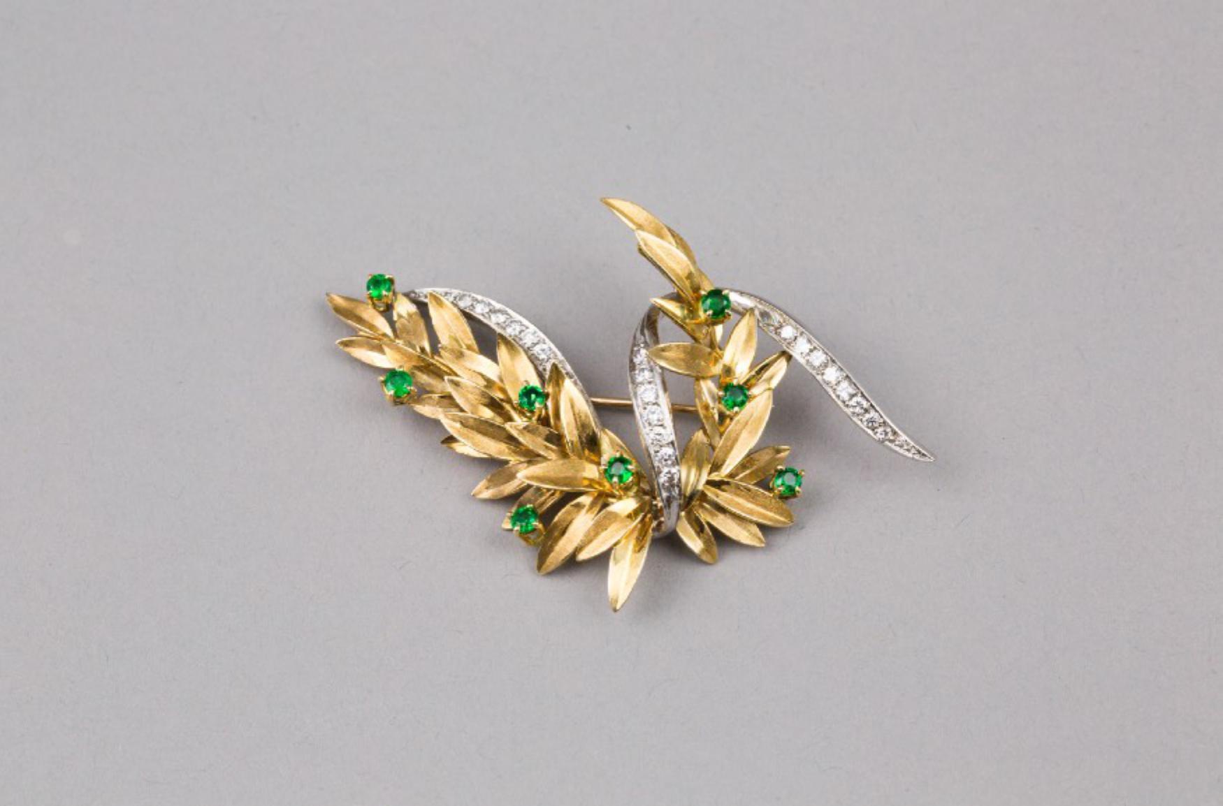 A 18K Yellow Gold Emerald and Diamond brooch
