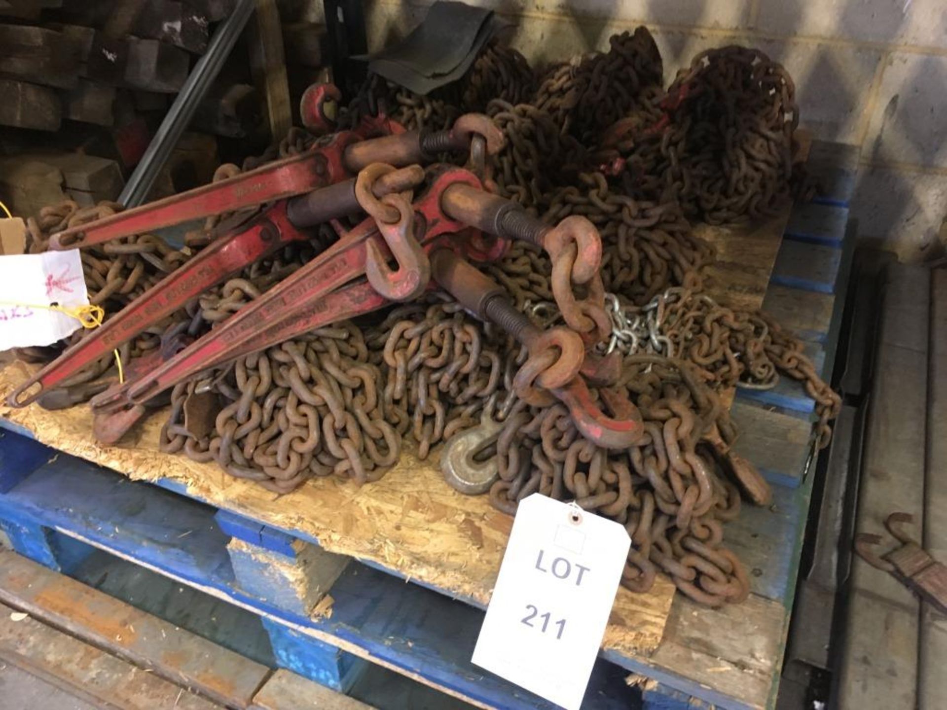 Assorted chains and load binders (some labelled as requiring repair) on one pallet. Please note: