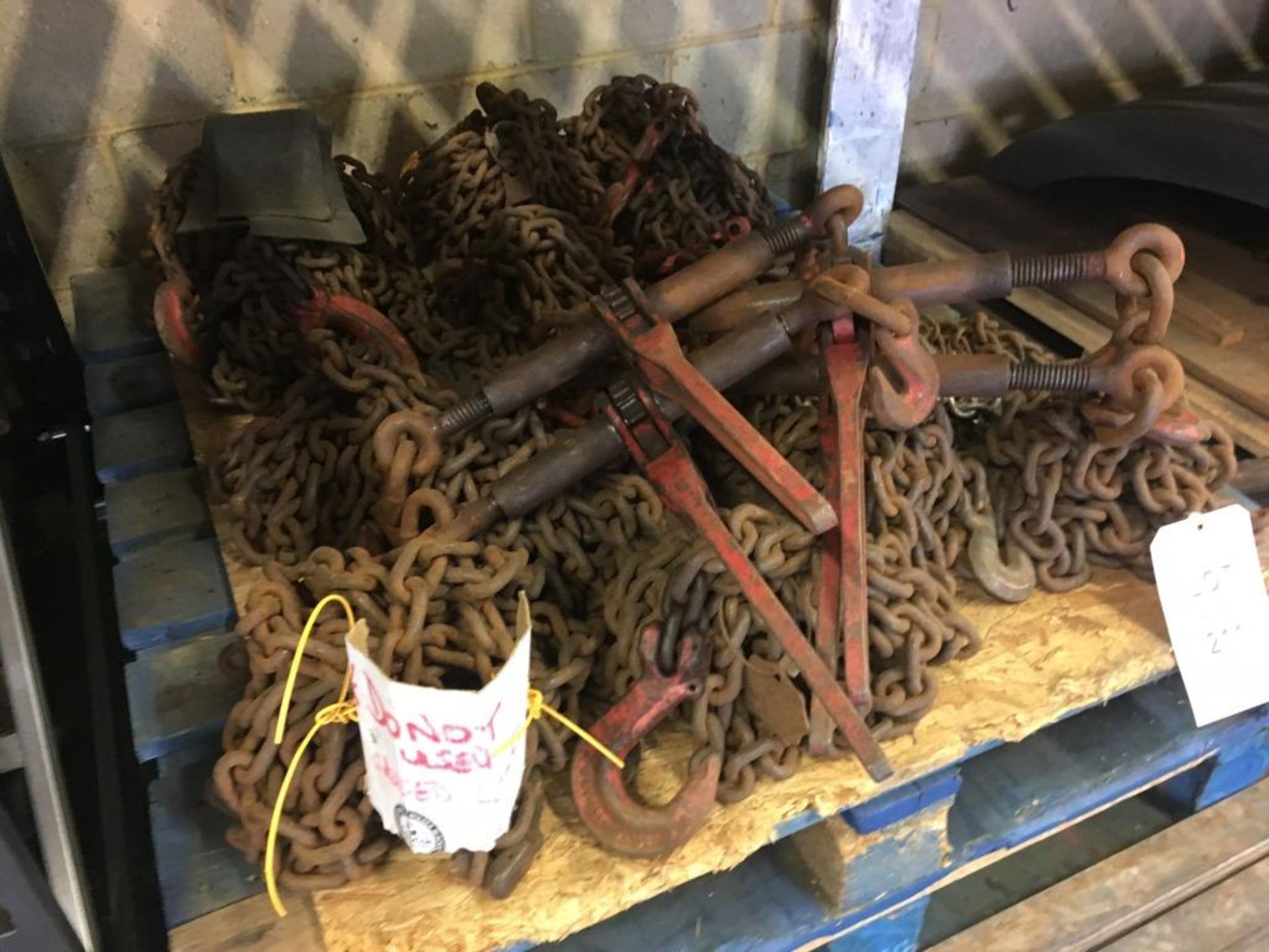 Assorted chains and load binders (some labelled as requiring repair) on one pallet. Please note: - Image 2 of 2