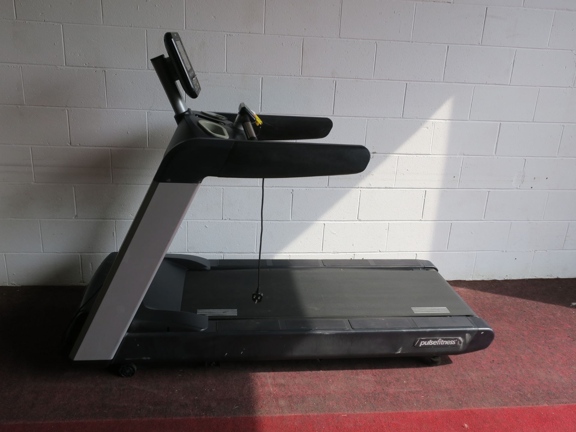 * A Pulse Fitness Model 260G Treadmill with interactive screen, heart rate monitors, cup holders,