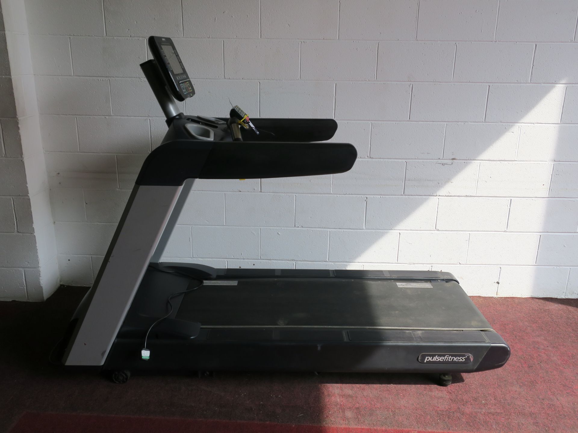 * A Pulse Fitness Model 260G Treadmill with interactive screen, heart rate monitors, cup holders,