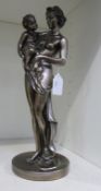 A Cast Metal Statuette of a Mother holding a Child (est £15-£25)