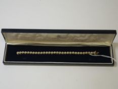 A Yellow Metal Tennis Bracelet Set with 30 Green Diamonds (est £50-£100)