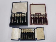 Three sets of six Hallmarked Silver Spoons, each cased. One set is plain with the other two