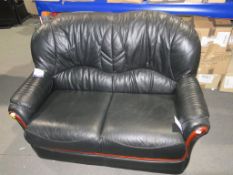 * A Black Leather Two Seater Sofa with Wood Effect Facia (est £40-£80)