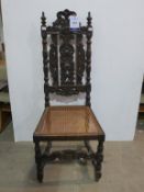 A Carved Oak Chair with Interwowen Cane Seat, with turned legs and stretchers (est £35-£70)