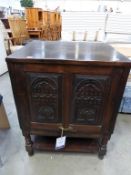 A solidly built TV Cabinet with Carved ' up and over Door' with Brass Handle Raised upon Turned Legs