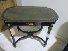 * An Antique Ebonised Table with leather insert, gold coloured highlights on original castors) (H