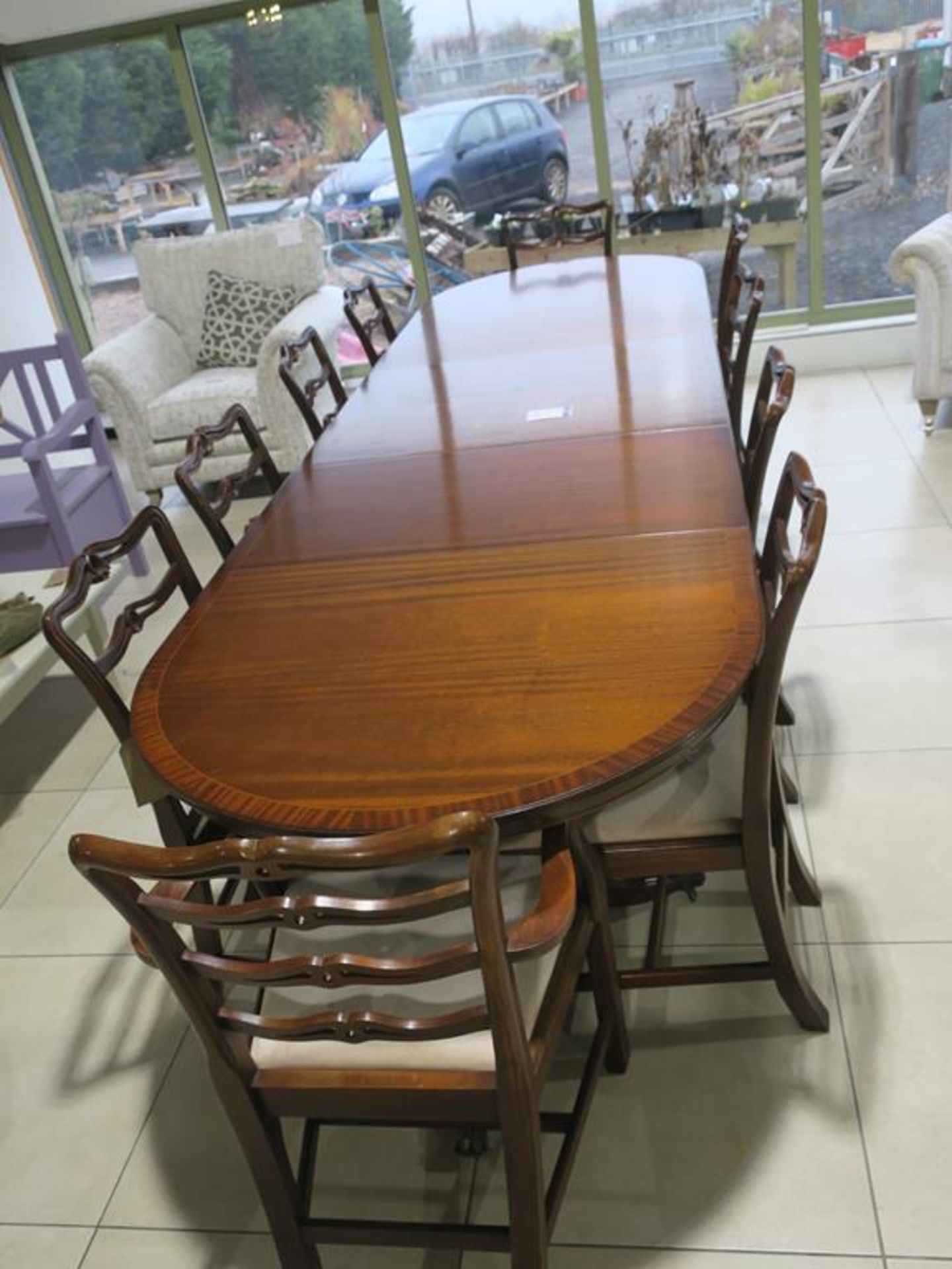 A Reproduction Mahogany Three Pedestal Dining Table with two Carver Ribbon Back Chairs and eight