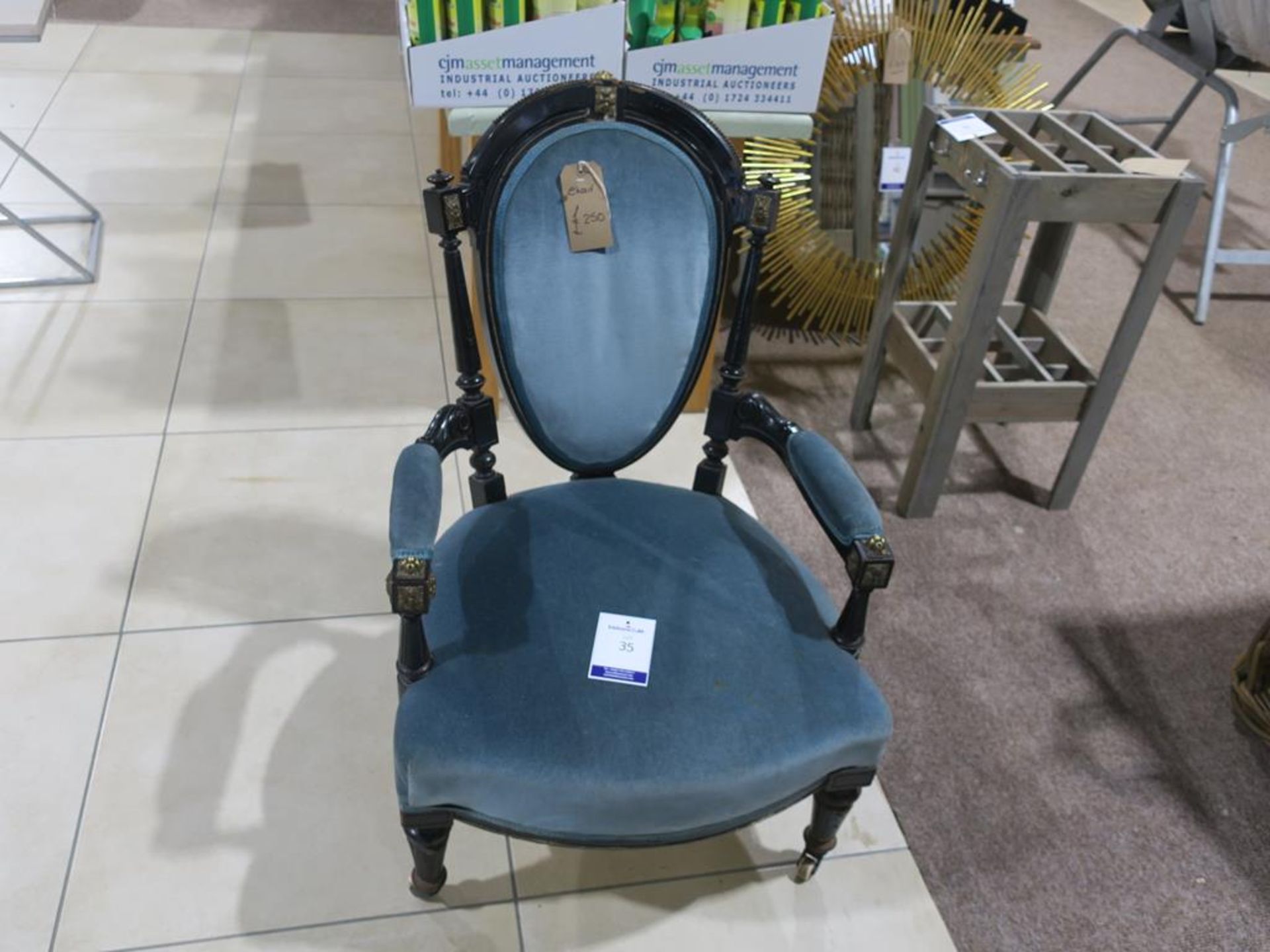 * An Ebonised Chair with turned and fluted supports with blue cushioned seat, arm rests and back