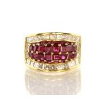 A ruby and diamond dress ring in 18ct yellow gold with a central oval bombe set with rubies,