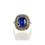 A Ceylon sapphire and diamond dress ring in yellow and white gold the cushion cut blue sapphire