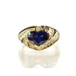 A sapphire and diamond dress ring in 18ct yellow gold the heart cut blue sapphire claw set within
