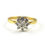 A diamond cluster dress ring in 9ct yellow gold set with nine round cut diamonds in a floral