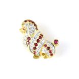 A jewelled ruby and diamond dog brooch in yellow gold modeled as a seated long haired dog in