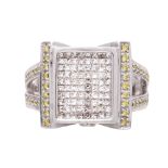 A fancy colour diamond dress ring in white gold, set with a face of eighty princess cut white