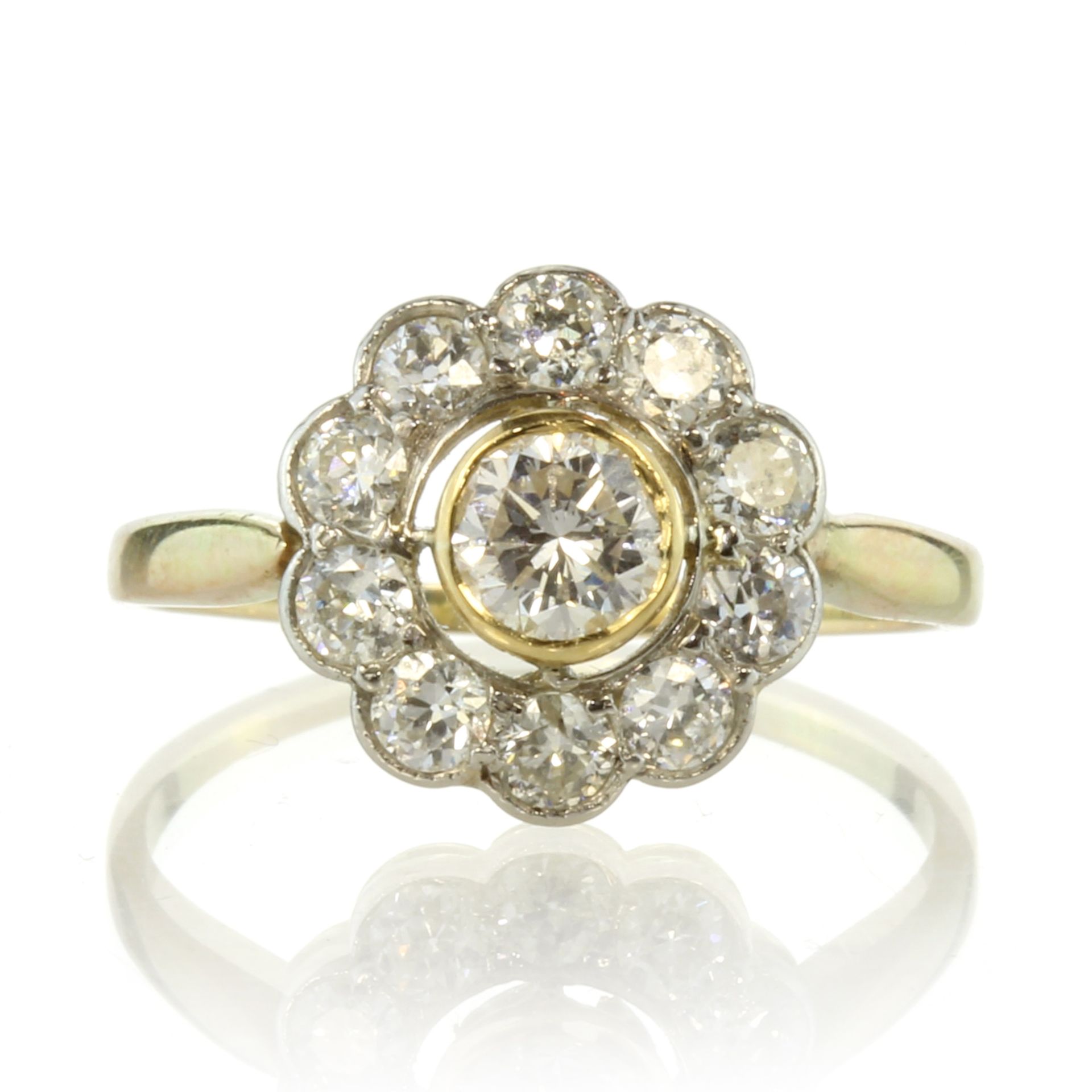 A diamond cluster dress ring in 18ct yellow gold set with a central round cut diamond surrounded