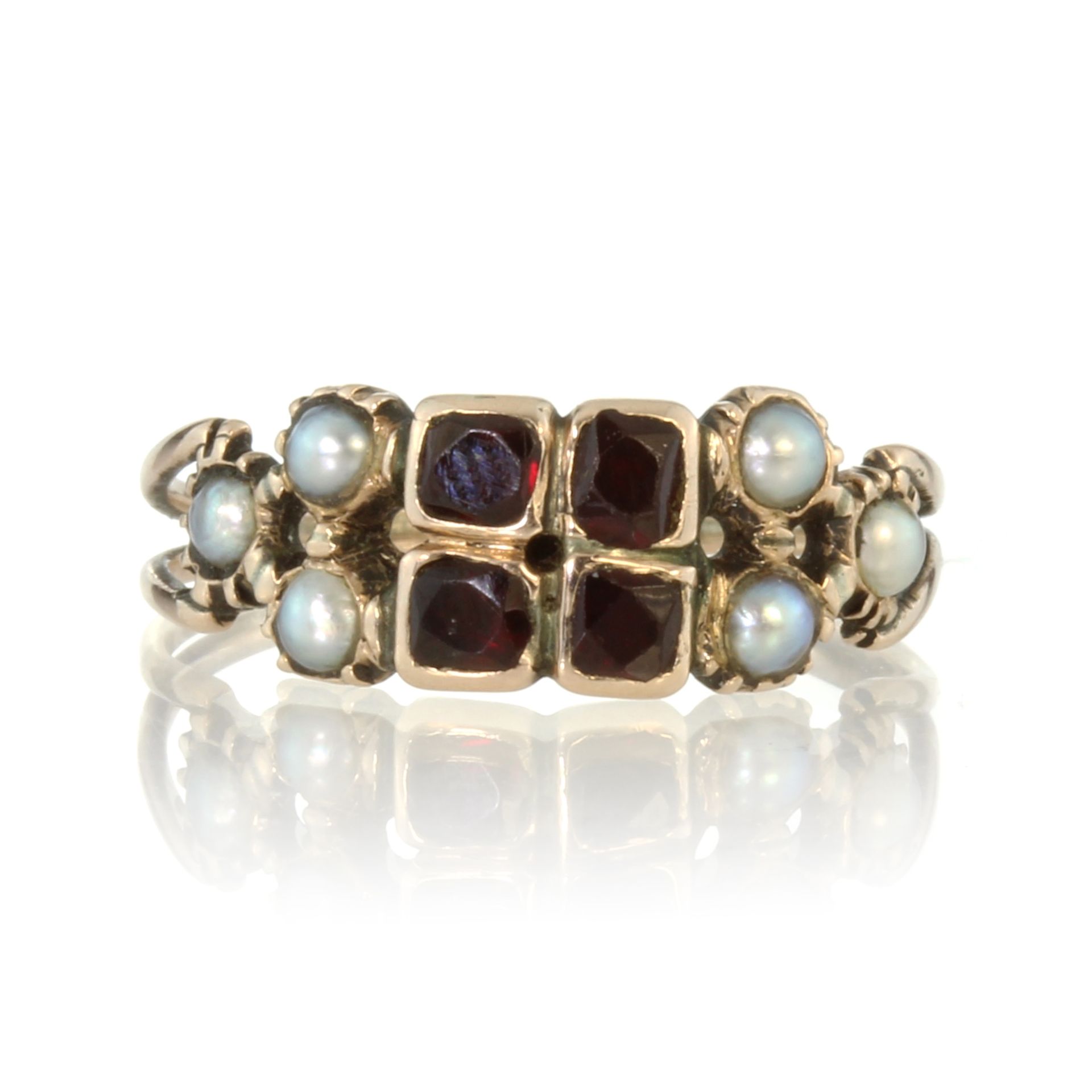 An antique Georgian garnet and seed pearl dress ring in high carat yellow gold, set with four old