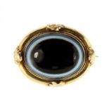 An antique Victorian banded agate mourning brooch the large cabochon measuring 25x19mm, surrounded