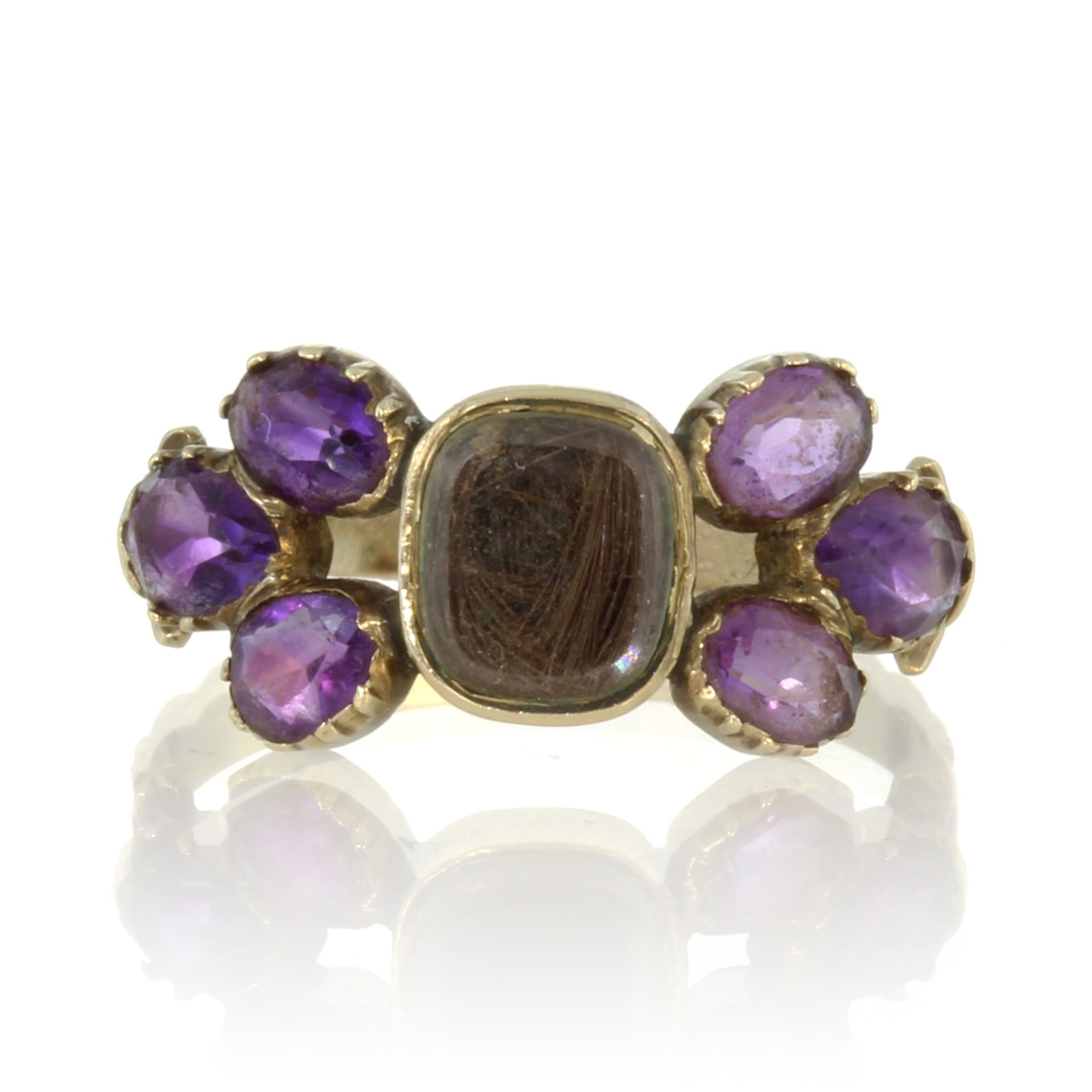 An antique Georgian hairwork and amethyst mourning ring in high carat yellow gold designed as a