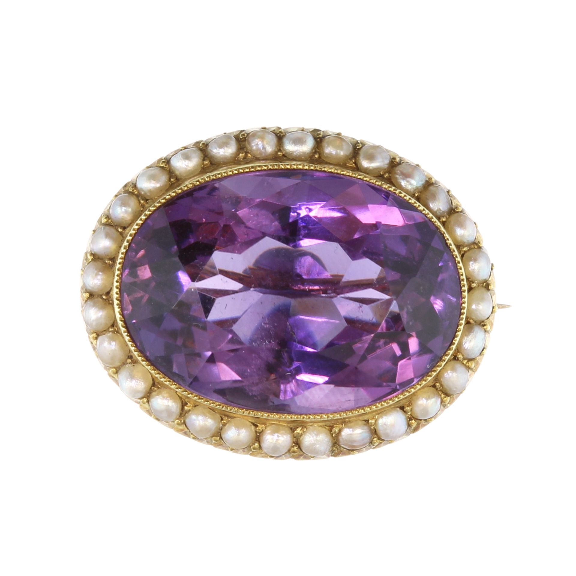 An antique amethyst and seed pearl cluster brooch in 15ct yellow gold the large oval cut amethyst