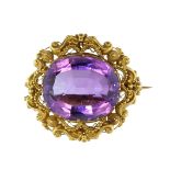 An antique 19th Century amethyst brooch in yellow gold set with a large oval cut amethyst weighing