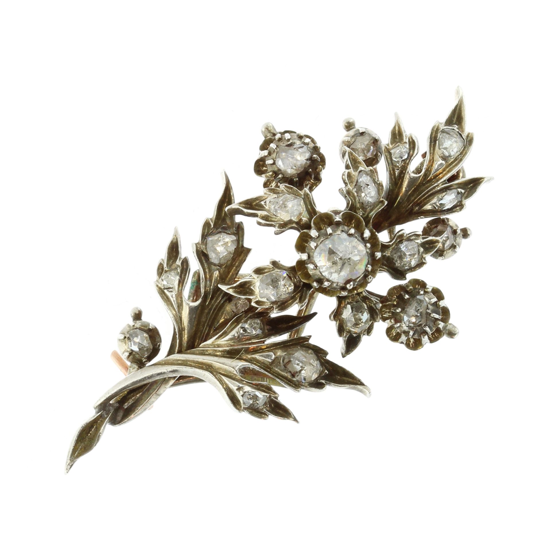 An antique jewelled diamond floral spray brooch in gold and silver designed as a spray of flowers