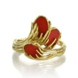 A vintage coral dress ring in 18ct yellow gold set with three oval panels of coral within a textured