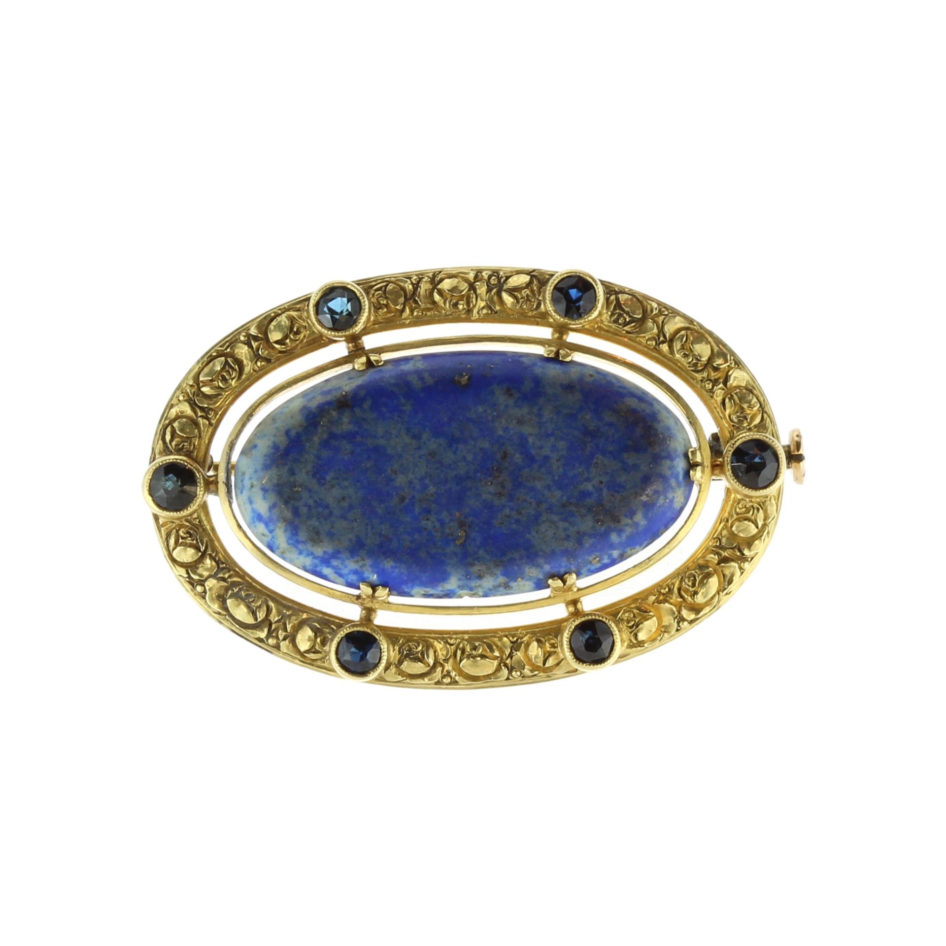 An antique lapis lazuli and sapphire brooch in high carat yellow gold set with a large oval lapis