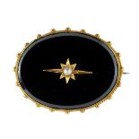 An antique Victorian onyx and pearl mourning brooch in high carat yellow gold designed a large