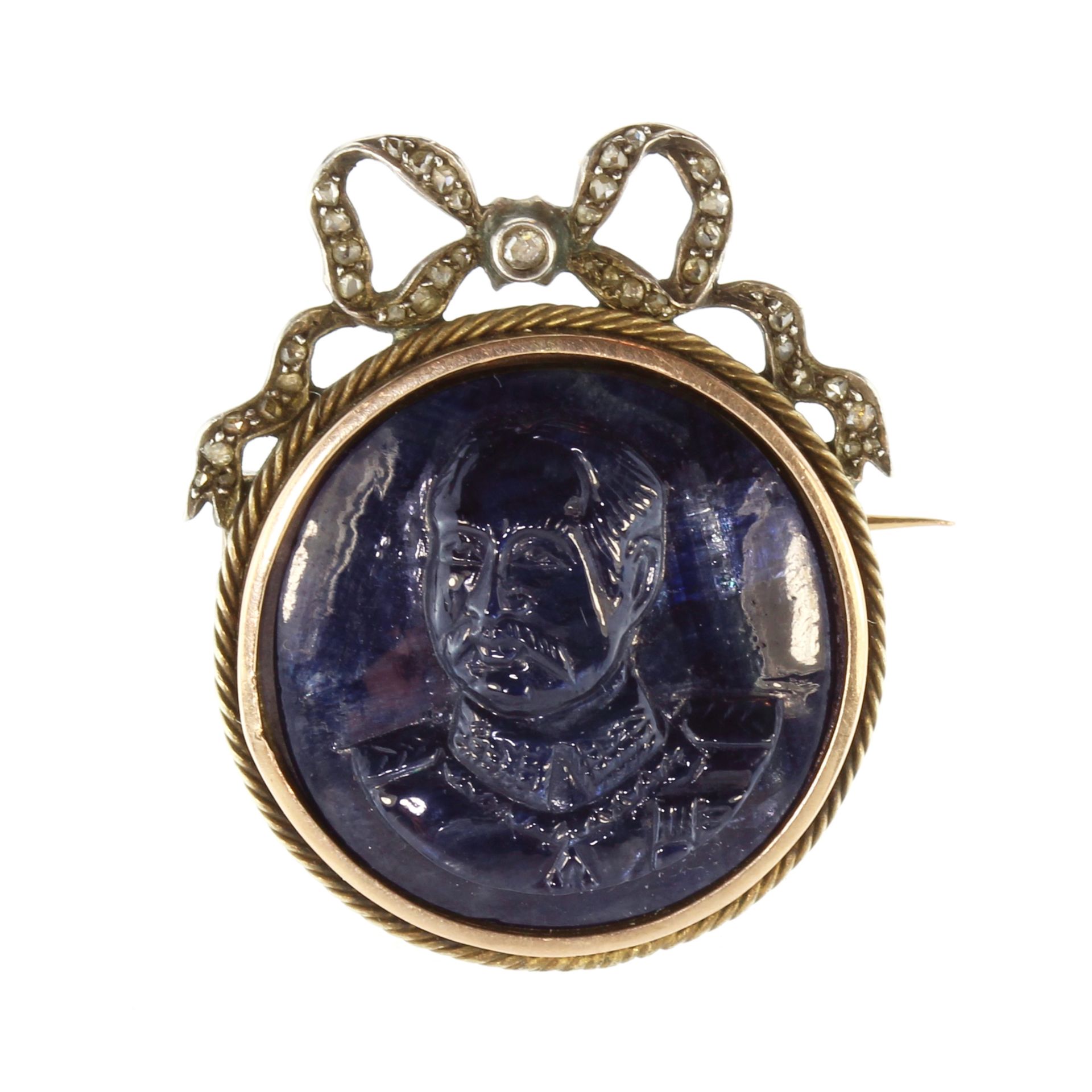 A French sapphire cameo and diamond brooch in gold and silver set with a large, circular carved blue