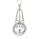 An antique diamond pendant in platinum or white gold, designed as a central round cut diamond of