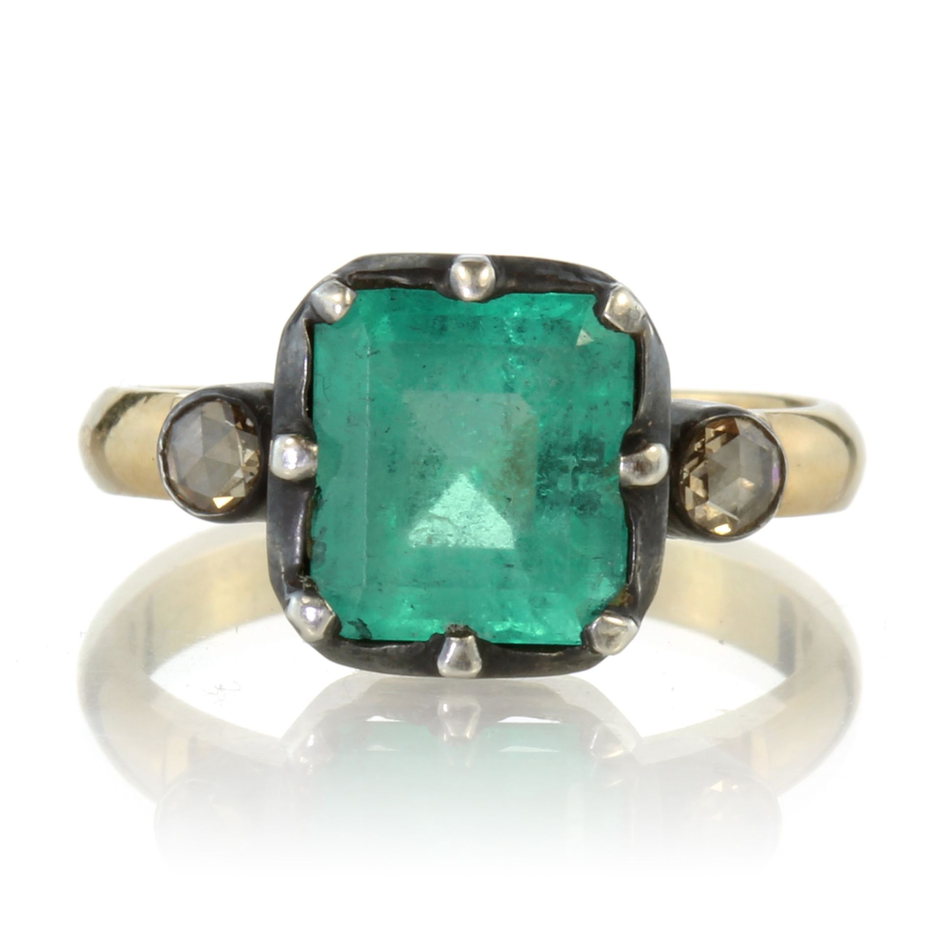 An emerald and diamond dress ring in 18ct yellow gold set with a central emerald cut emerald of